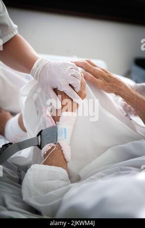 Two physiotherapists mobilize a patient in the intensive care unit of the hospital. Stock Photo