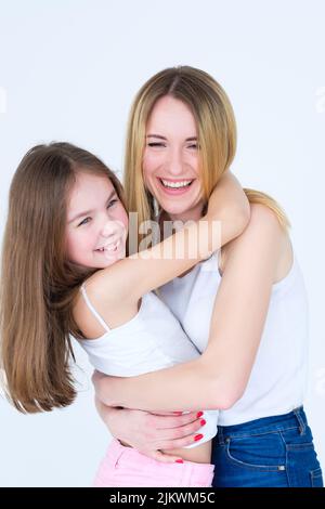 Loving mom hug little daughter hold red heart shaped balloons, express