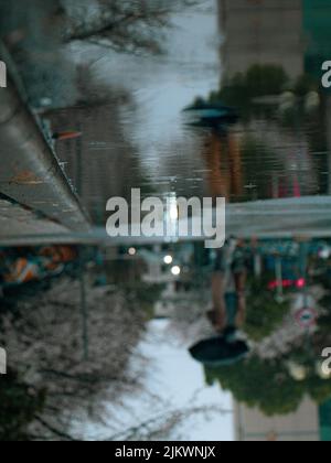 Puddle on pavement. After rain. Road in pits. Reflection of sky in ...