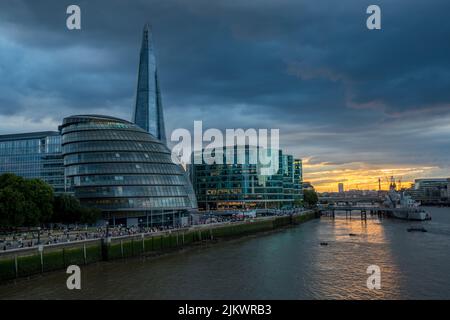 The sun sets over the city of London allowing just the Rover Thames to be lit up in golden light during July 2022. Stock Photo