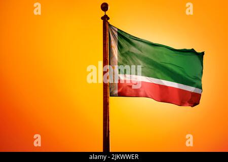 A digital illustration of the flag of Chechnya waving against a bright yellow sky Stock Photo