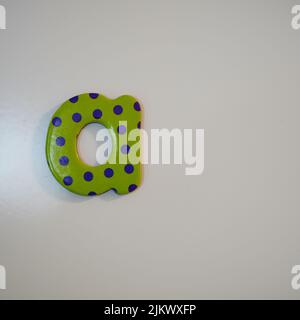 A cardboard lowercase letter "a" with polka dot pattern on a gray background Stock Photo