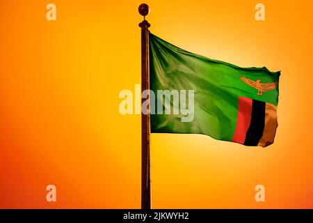 The flag of Zambia on a bright yellow background Stock Photo