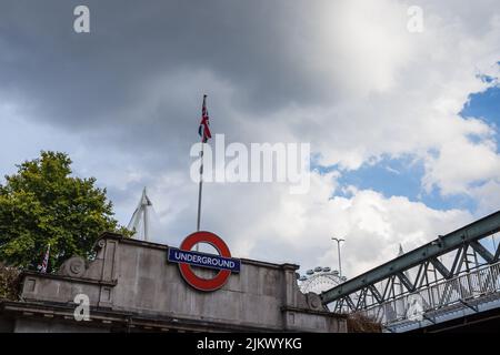 Looking up at the London Underground logo above Embankment station with a Union Jack stood on top in August 2022. Stock Photo