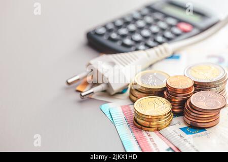 The energy savings concept with power plug and euro money on gray table. Stock Photo