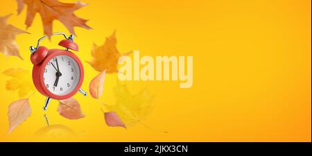 Red alarm clock and flying leaves on autumnal orange background. Back to school concept. Stock Photo