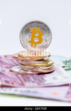 Bitcoins coins on top of 100 and 500 Euros bank notes. Bitcoin on one hundred and five hundred euro banknotes. Cryptocurrency bitcoin and Euros Stock Photo