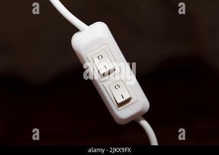 New double plastic switch for desk lamp connected to wire on dark background Stock Photo