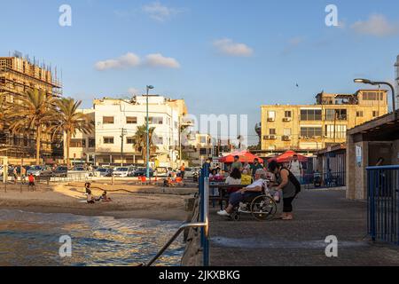 Haifa, Israel - 20 July 2022, Bat Galim beach. People gather on the embankment to watch the sunset. Stock Photo