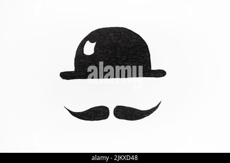 Photo of a drawing of a black hat and mustache on white paper Stock Photo