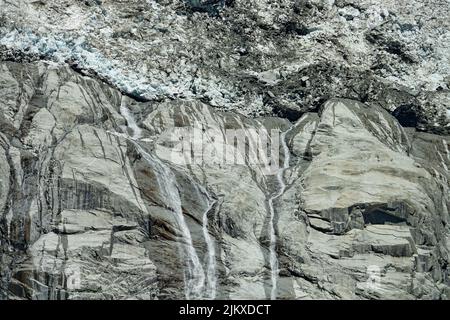 Climate change. View of the Brenva glacier melting creating large waterfalls. Courmayeur, Italy Stock Photo