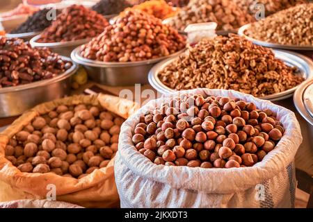 hazelnuts in shell, walnut and other nuts and dried fruits and raisins on the farmers counter at the local market or oriental bazaar Stock Photo