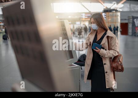 Young lady touching interactive screen to check in online Stock Photo