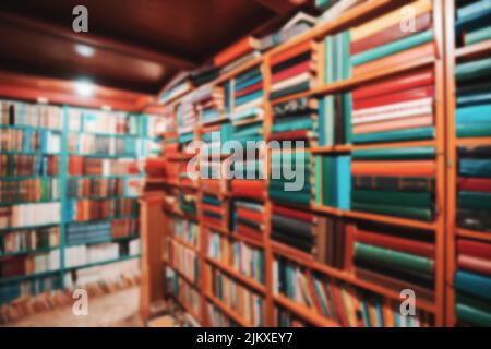 Blurred background from a library with lots of books on the shelves. Education and learning concept Stock Photo