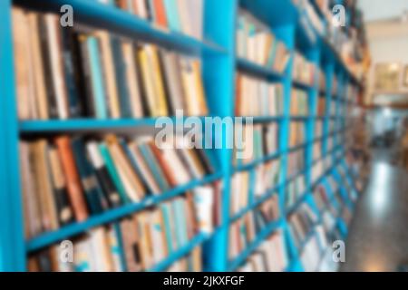 Blurred background from a library with lots of books on the shelves. Education and learning concept Stock Photo