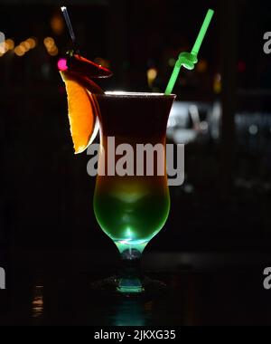 A vertical closeup of a fruit cocktail isolated on dark background. Stock Photo