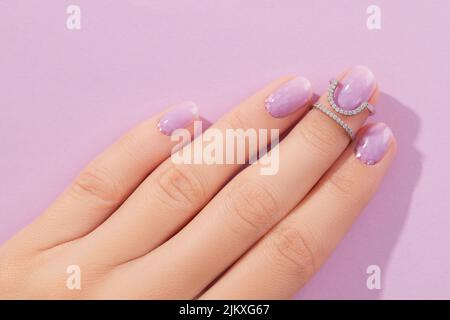 Womans hand with trendy lavender manicure. Spring summer nail design