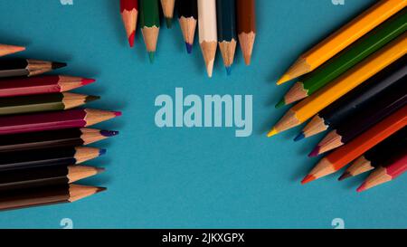 A bunch of color pencil on a blue background. Selective focus on the pencil color Stock Photo