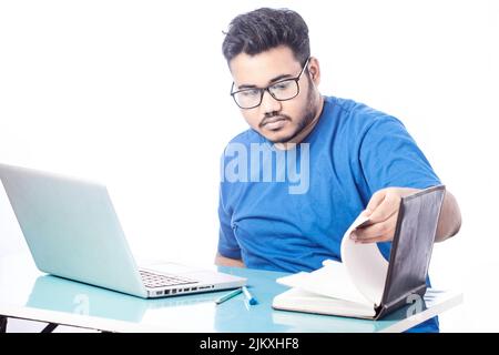 serious business man working on laptop and searching something on a notebook diary Stock Photo