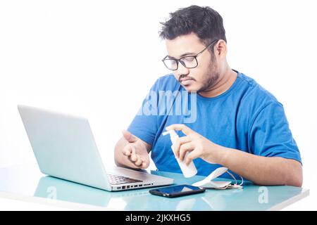 corporate man sanitizing hands before using laptop Stock Photo