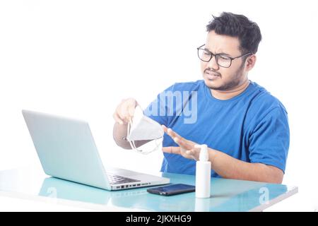 angry man hate to use mask while working on laptop Stock Photo