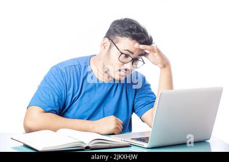 young man feeling exhausted by working on laptop, man got headache watching at computer screen Stock Photo