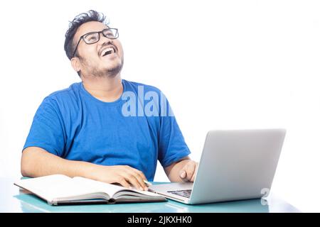 male student laughing when talking on video calling in white background Stock Photo