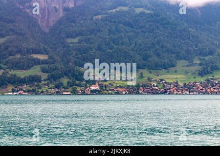 The beautiful view of Lake Brienz and the small town on the mountain slope. Interlaken, Switzerland. Stock Photo