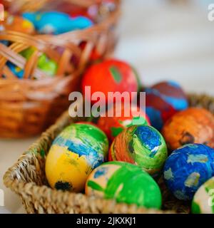 The colorful painted eggs in a straw basket for Easter Stock Photo