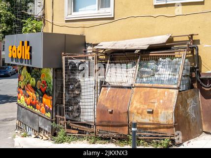 Rusty plastic waste container, air conditioners and fruits shop in Kadikoy, Istanbul, Turkey Stock Photo