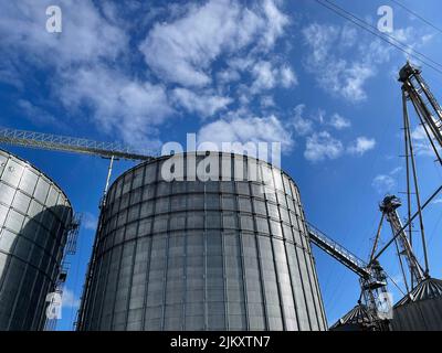 Burke County, Ga USA - 12 27 21: Industrial Silver Metal Silo and blue sky with clouds Stock Photo