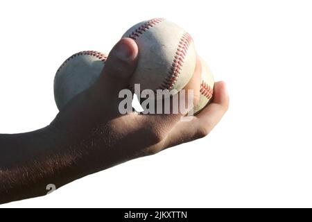 Closeup of a male hand holding three baseballs isolated against a white background. Stock Photo