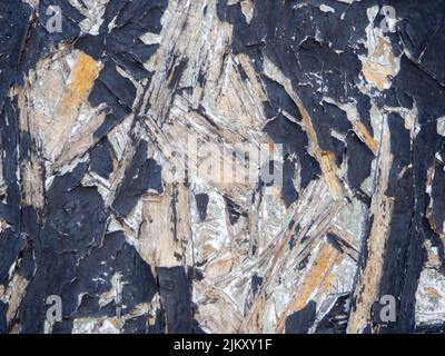 Chipboard in black paint. Background from a painted board. Pattern. Wooden background. Compressed chips. Old shabby wall Stock Photo