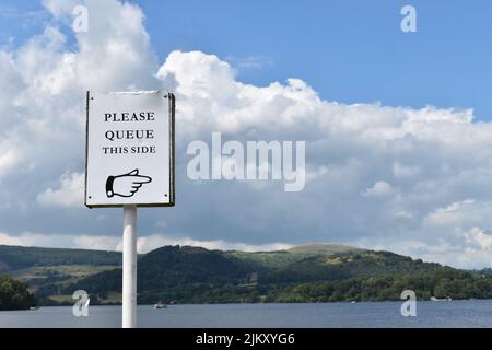 Notice: 'Please queue this side' with copy space. Stock Photo