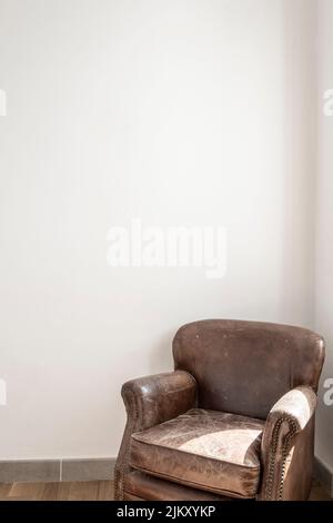 brown leather armchair and an empty white wall Stock Photo