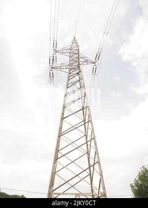 A low angle shot of high voltage power lines during a cloudy day Stock Photo
