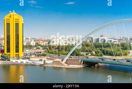 Ramstore or Karaotkel bridge over Ishim river.  Nur-Sultan, Astana, Kazakhstan.  Bussines Center Astana Tower yellow building Stock Photo