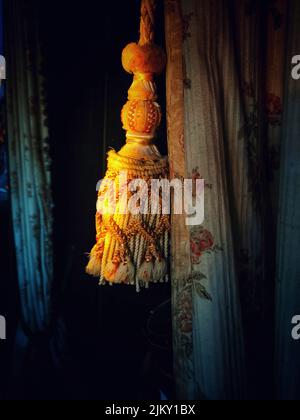 A vertical closeup shot of ornamental fringe hanging from the curtains Stock Photo