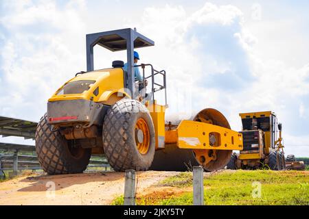 Soil compactor is working to compact the road to make the soil firm according to specified standards before paving the road with asphalt, construction Stock Photo
