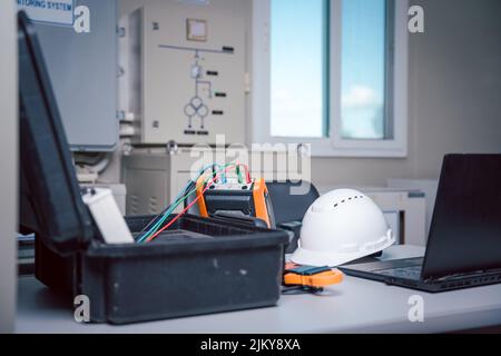 Safety helmet with the solar panel performance check tool and notebook put on the working table of engineer so that prepare to check the data obtained Stock Photo