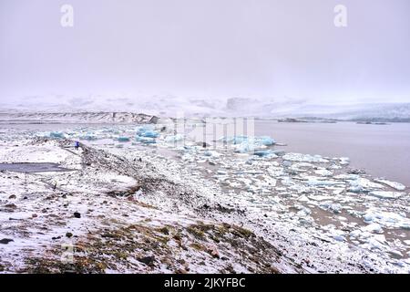 Snowy landscape showing many icebergs floating in Fjallsarlon Glacier Lake Southern Iceland Stock Photo