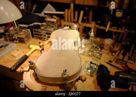 A wooden violin being made in a workshop Stock Photo