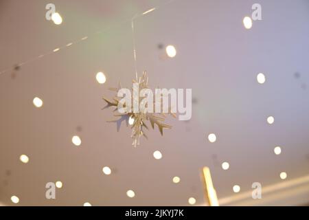 A beautiful snowflake decoration for Christmas hanging on a blurred background Stock Photo