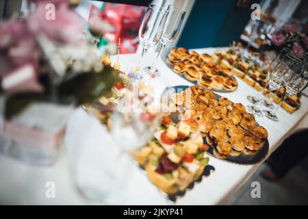 A shallow focus shot of the buffet and wine glasses on the table in the restaurant Stock Photo