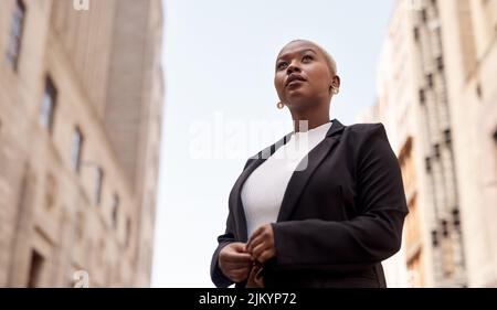 I have a goal and Im going to get to it. Low angle shot of a young businesswoman looking thoughtful while standing in the city. Stock Photo