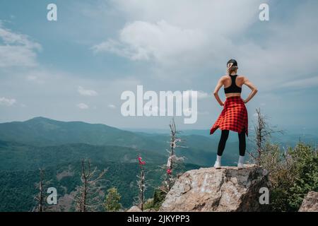 A girl on top of Falaza mountain looks at a beautiful mountain valley. Travel and tourism. Hiking High quality photo Stock Photo