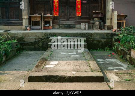 A beautiful shot of a stone old floor with little grass with stairs to Chinese texts banners Stock Photo