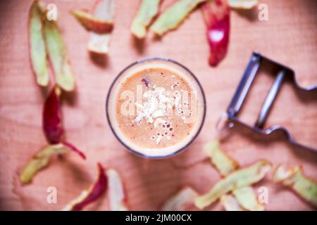 The first wealth is health. Overhead shot of an apple smoothie topped with sliced almonds on a wooden board. Stock Photo