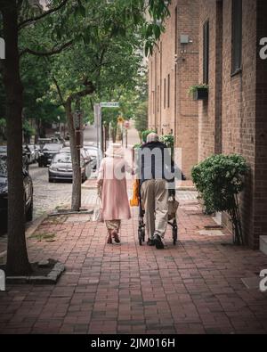 A senior couple with an elegant outfit walking in the city street Stock Photo