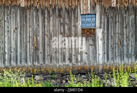The weathered wall and window of an abandoned barn in central Oregon Stock Photo